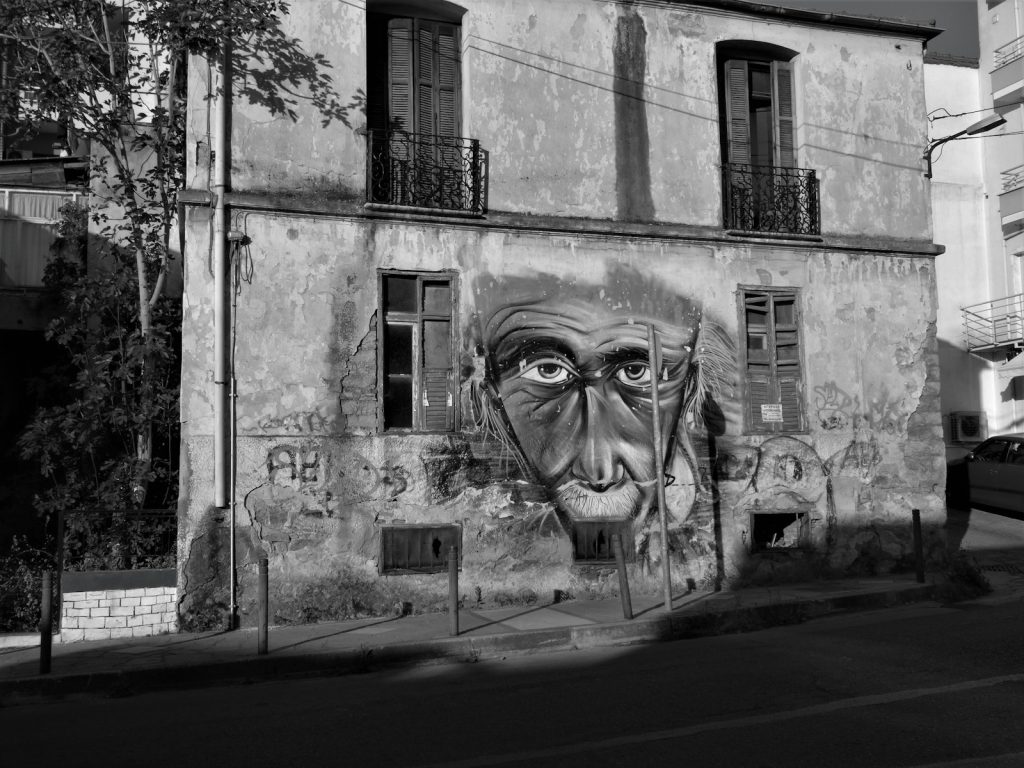 a black and white photo of a building with a face painted on it