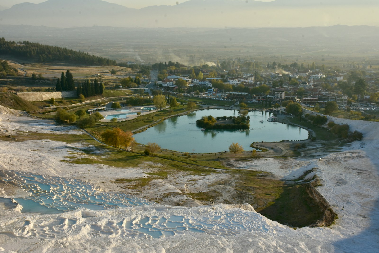 a small lake surrounded by snow covered hills